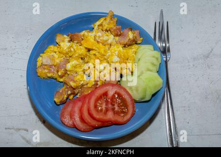 Scrambled eggs with bacon in a pan. Stock Photo