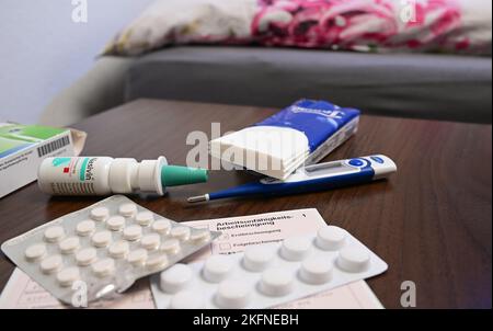 Stuttgart, Germany. 18th Nov, 2022. A fever thermometer, medication and a doctor's certificate of incapacity for work (sick note) are lying on a bedside table (posed scene). With the cold season, influenza infections are on the rise again. (to dpa: 'Already in autumn as many flu cases as in complete previous season') Credit: Bernd Weißbrod/dpa/Alamy Live News Stock Photo