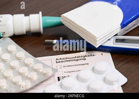 Stuttgart, Germany. 18th Nov, 2022. A fever thermometer, medication and a doctor's certificate of incapacity for work (sick note) are lying on a bedside table (posed scene). With the cold season, influenza infections are on the rise again. (to dpa: 'Already in autumn as many flu cases as in complete previous season') Credit: Bernd Weißbrod/dpa/Alamy Live News Stock Photo