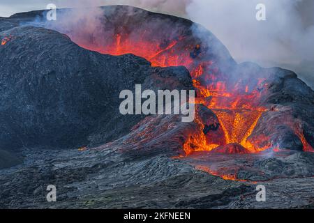 View into crater opening from the side. Lava flow from the crater of a volcano on Iceland. Landscape on Reykjanes Peninsula in GeoPark. Heavy smoke Stock Photo