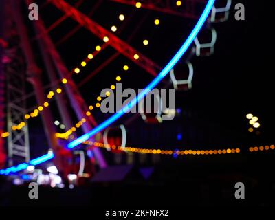 Blurred background picture of a Ferris Wheel at night with bokeh effects. Stock Photo