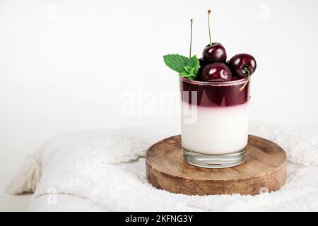 Gelatin dessert. Yoghurt and cherry jelly in a glass. Stock Photo