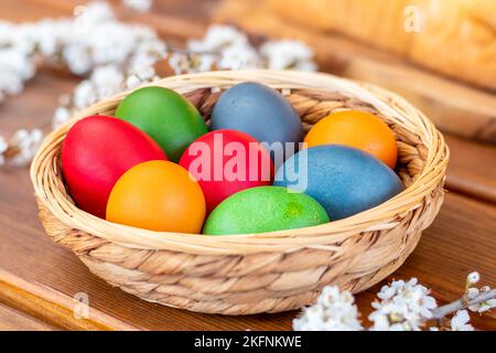 Easter eggs, dyed hen eggs in a wicker basket bowl Stock Photo