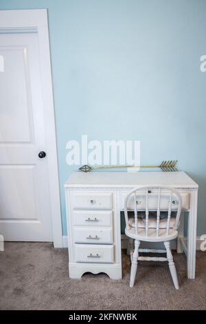 A small white child's desk and chair in a pale blue bedroom in a new construction house Stock Photo