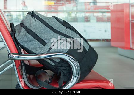 A lonely backpack at the airport in the waiting room. Forgotten luggage. Lost hand luggage. The concept of travel. Stock Photo