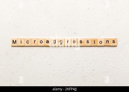 Microaggressions word written on wood block. Microaggressions text on cement table for your desing, concept. Stock Photo