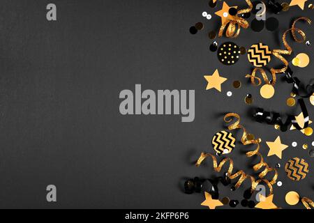 New Years Eve side border of gold and black confetti, streamers and ...