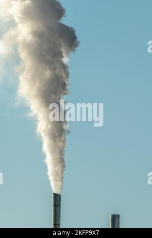 Column of smoke coming out of an industrial chimney. France. Stock Photo