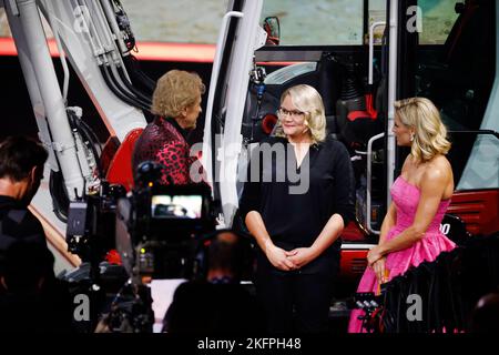 Friedrichshafen, Germany. 19th Nov, 2022. Excavator driver Sandra Hasenauer (M) performs her excavator weather on the ZDF show 'Wetten, dass.?' with Thomas Gottschalk and Michelle Hunziker. Following the successful comeback in November 2021, there will also be a revival of the legendary ZDF Saturday night show in 2022. Credit: Philipp von Ditfurth/dpa/Alamy Live News Stock Photo