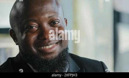 Thoughtful african american businessman plus size thick man employer professional agent entrepreneur manager business person looking at camera smiling Stock Photo
