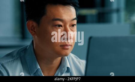 Close up portrait chinese japanese focused man professional asian korean worker web designer businessman work with computer program use office laptop Stock Photo