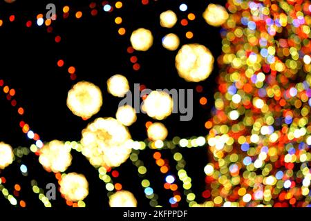 New Year's Christmas tree decorated with luminous multi-colored garlands and illumination at night. Christmas tree with flashing lights. Blurred background. New Year Christmas holidays. Stock Photo