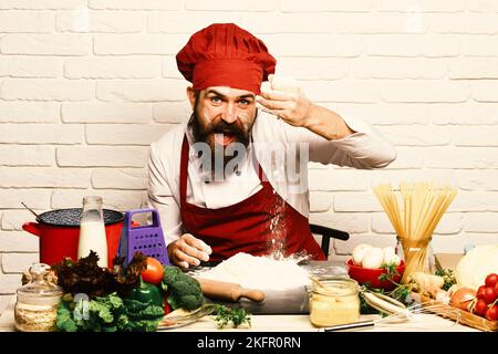 Chef makes dough. Man with beard plays with flour Stock Photo