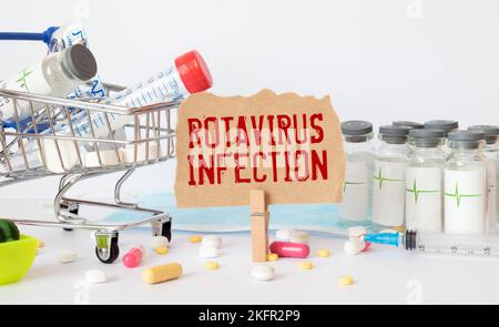 Medical concept. On a brown surface lies a stethoscope, pills and a notepad with the inscription - Rotavirus infection Stock Photo