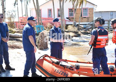Vice Adm. Kevin E. Lunday, commander, Atlantic Area, and Master Chief Jeremy P. DeMello, command master chief, Atlantic Area, center-left, visit Coast Guard personnel conducting response operations in the wake of Hurricane Ian, Matlacha, Florida, Oct. 2, 2022. The Coast Guard worked with state and local agencies, plus good Samaritans, to ensure the residents of Pine Island had transportation to the mainland as well as access to clean water and food.