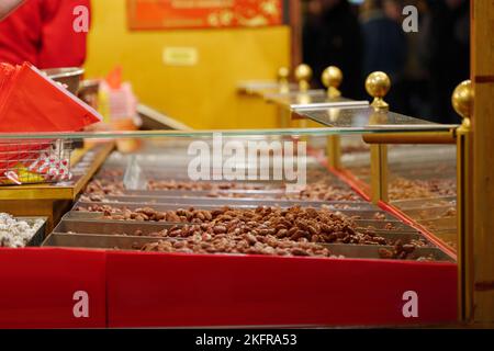 Selective focus at heap of roasted almond on the stall at Christmas market. Stock Photo
