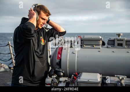 221004-N-ZQ263-1017 PACIFIC OCEAN (Oct. 4, 2022) U.S. Navy Sonar Technician (Surface) 3rd Class Herik Milliron, from Pittsburgh, communicates with the underwater fire control system operator while conducting tests of the over- the- side torpedo tubes aboard the Arleigh Burke-class guided-missile destroyer USS Chung-Hoon (DDG 93). Chung-Hoon is operating with Nimitz Carrier Strike Group in preparation for an upcoming deployment. Stock Photo