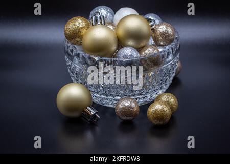Macro abstract view of a beautiful crystal bowl with sparkling glitter holiday balls, with dark background Stock Photo