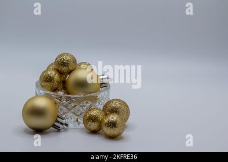 Macro abstract defocused view of a beautiful small crystal bowl with sparkling glitter holiday balls, with white background Stock Photo