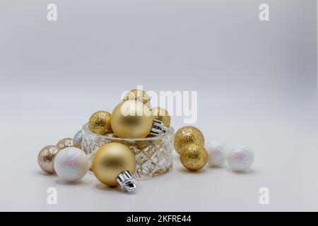 Macro abstract defocused view of a beautiful small crystal bowl with sparkling glitter holiday balls, with white background Stock Photo