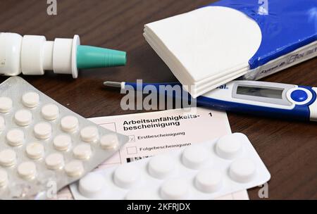 Stuttgart, Germany. 18th Nov, 2022. A fever thermometer, medication and a doctor's certificate of incapacity for work (sick note) are lying on a bedside table (posed scene). With the cold season, influenza infections are on the rise again. Credit: Bernd Weißbrod/dpa/Alamy Live News Stock Photo