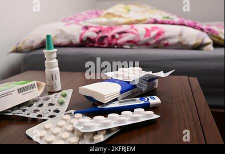 Stuttgart, Germany. 18th Nov, 2022. A fever thermometer and medications lie on a bedside table (posed scene). With the cold season, influenza infections are on the rise again. Credit: Bernd Weißbrod/dpa/Alamy Live News Stock Photo