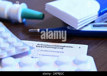 Stuttgart, Germany. 18th Nov, 2022. A fever thermometer, medication and a doctor's certificate of incapacity for work (sick note) are lying on a bedside table (posed scene). With the cold season, influenza infections are on the rise again. Credit: Bernd Weißbrod/dpa/Alamy Live News Stock Photo