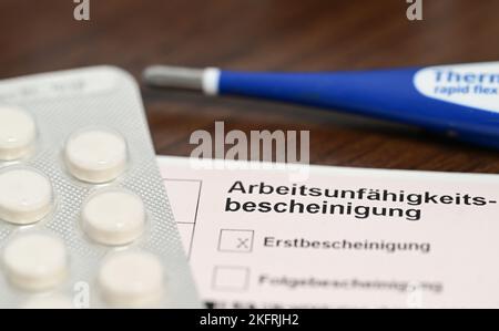 Stuttgart, Germany. 18th Nov, 2022. A fever thermometer, medication and a doctor's certificate of incapacity for work (sick note) are lying on a bedside table (posed scene). With the cold season, influenza infections are on the rise again. Credit: Bernd Weißbrod/dpa/Alamy Live News Stock Photo