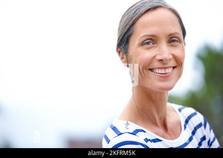 Make the most of your life. Cropped portrait of an attractive mature woman in casualwear standing outdoors. Stock Photo