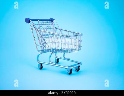 empty shopping cart over colour background, mini metal cart isolated on color background Stock Photo