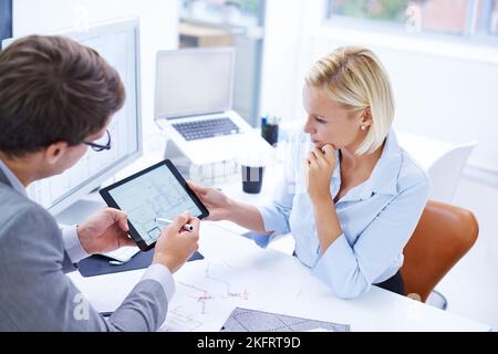 Quality control is more efficient with digital media. a architect showing plans to his colleague on a digital tablet. Stock Photo