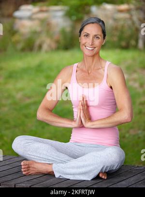 Peace in nature. an attractive mature woman practicing yoga in the lotus position. Stock Photo