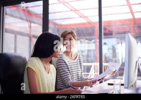 These are the figures were working with for the month. two colleagues working together at a desk. Stock Photo