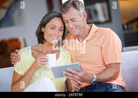 What do you think. a loving mature couple using a digital tablet at home. Stock Photo