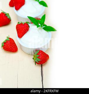 Organic Greek yogurt and strawberry over white rustic wood table Stock Photo