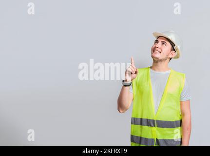 Builder engineer pointing finger to the right isolated, Portrait of engineer man pointing aside, Construction engineer with vest pointing at an advert Stock Photo