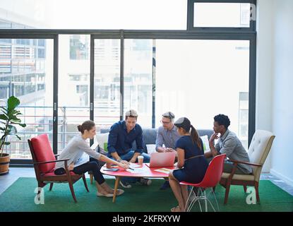 Developing new strategies. a group of office workers talking together in a meeting room. Stock Photo