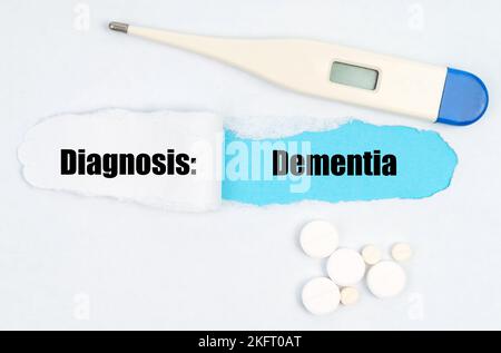 Medical diagnosis. A gap is made in the middle of the white sheet, inside of which there is an inscription - Dementia on a blue background. On the she Stock Photo