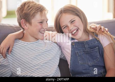 Children, siblings and hug on sofa laughing for sister and brother fun relaxing together at home. Happy portrait smile of kids in funny sibling Stock Photo