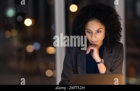 Night, overtime and business woman on a laptop working late on a corporate project in her office. Professional, dark and company manager planning Stock Photo