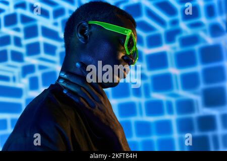 Young African American male touching his neck in ultraviolet light with 3D cubes Stock Photo