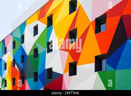 From below of colorful geometric building with colorful geometric ornament and windows on wall in city Stock Photo