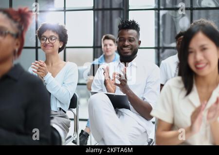 businesswoman applauding during seminar near interracial colleagues Stock Photo