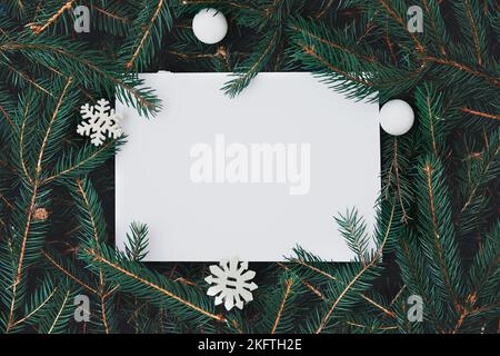 Creative layout made of Christmas tree branches with paper card note. Nature New Year concept. Stock Photo