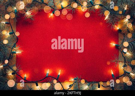 Red glitter paper letter texture background with Christmas tree branches and Christmas lights Stock Photo