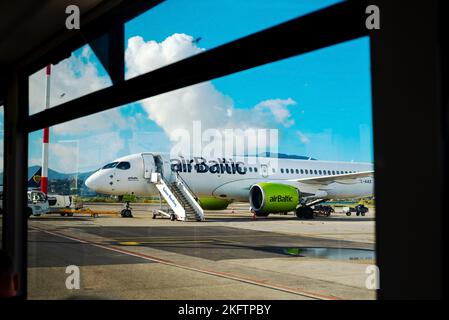 Kerkyra, Greece - 09 29 2022: View From Window of Corfu Airport On Green Plane of AirBaltic. Parking Lot For Aircraft, Aircraft Is Loaded With Luggage Stock Photo
