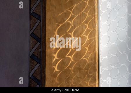 Sun shining through circled frosted glass and casting shadow on the wall Stock Photo