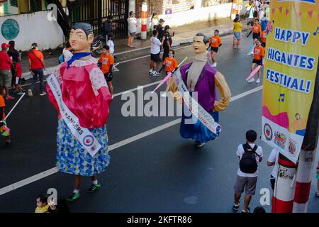 Angono, Rizal, Philippines. 20th Nov, 2022. The parade of the giant puppets in the art capital of the Philippines is back after two years of pandemic. The Higantes (giant) Festival parades the streets of Angono, Rizal province. The paper mache head puppets were originally done to put to shame corrupt officials during the Spanish rulership. Now, the Higantes came a long way and evolve into a festival on modern times from the Spanish era. The festival brings joy and entertainment to the town people of Angono and to tourists. Now, they wear a sash to represent someone or promote something with Stock Photo