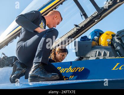 OAKLAND, California (Oct. 07, 2022) Aviation Electrician's Mate 2nd Class Sean Donoghue, assigned to the Navy Flight Demonstration Squadron, the Blue Angels, straps Monica Barbaro, Top Gun: Maverick actress, into the back seat of an F/A-18 Super Hornet during Fleet Week San Francisco. Stock Photo