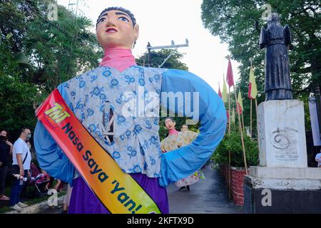 Angono, Rizal, Philippines. 20th Nov, 2022. The parade of the giant puppets in the art capital of the Philippines is back after two years of pandemic. The Higantes (giant) Festival parades the streets of Angono, Rizal province. The paper mache head puppets were originally done to put to shame corrupt officials during the Spanish rulership. Now, the Higantes came a long way and evolve into a festival on modern times from the Spanish era. The festival brings joy and entertainment to the town people of Angono and to tourists. Now, they wear a sash to represent someone or promote something with Stock Photo